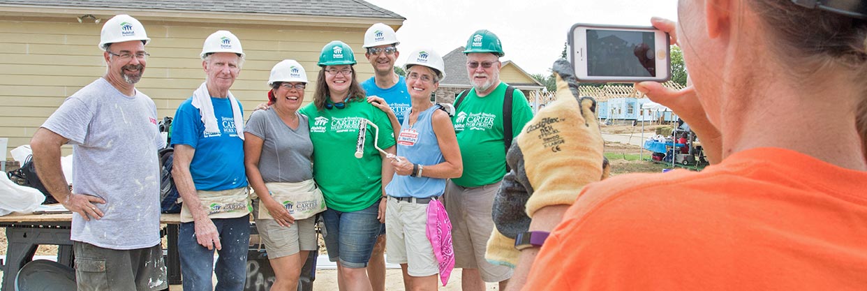 A group of volunteers pose for a photo on a work site