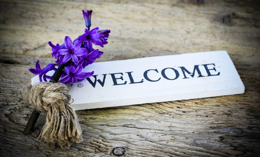 Decorative photo of a welcome sign and flowers